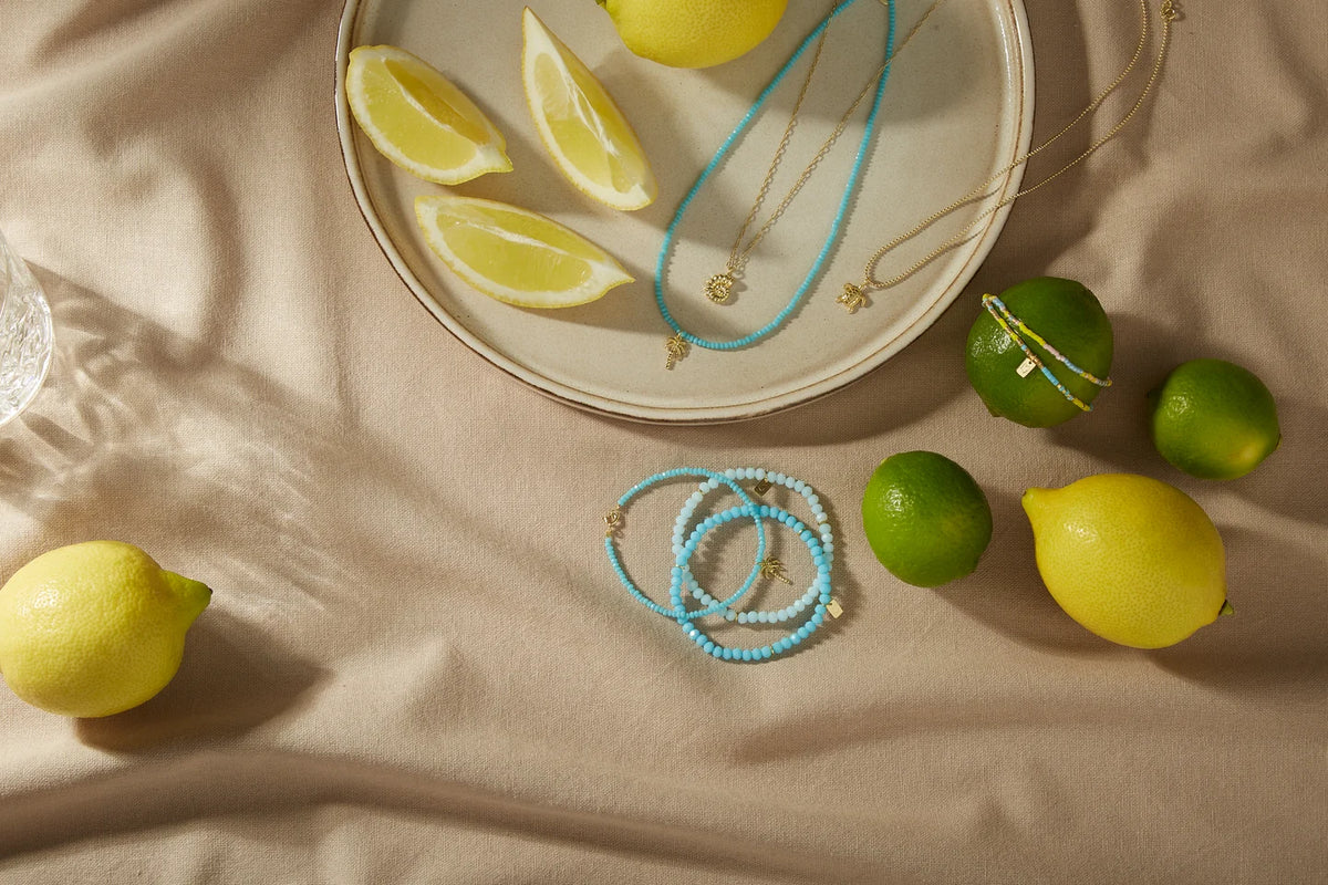Sommerlicher Schmuck mit türkisfarbenen Details zwischen Zitronen und Limetten.